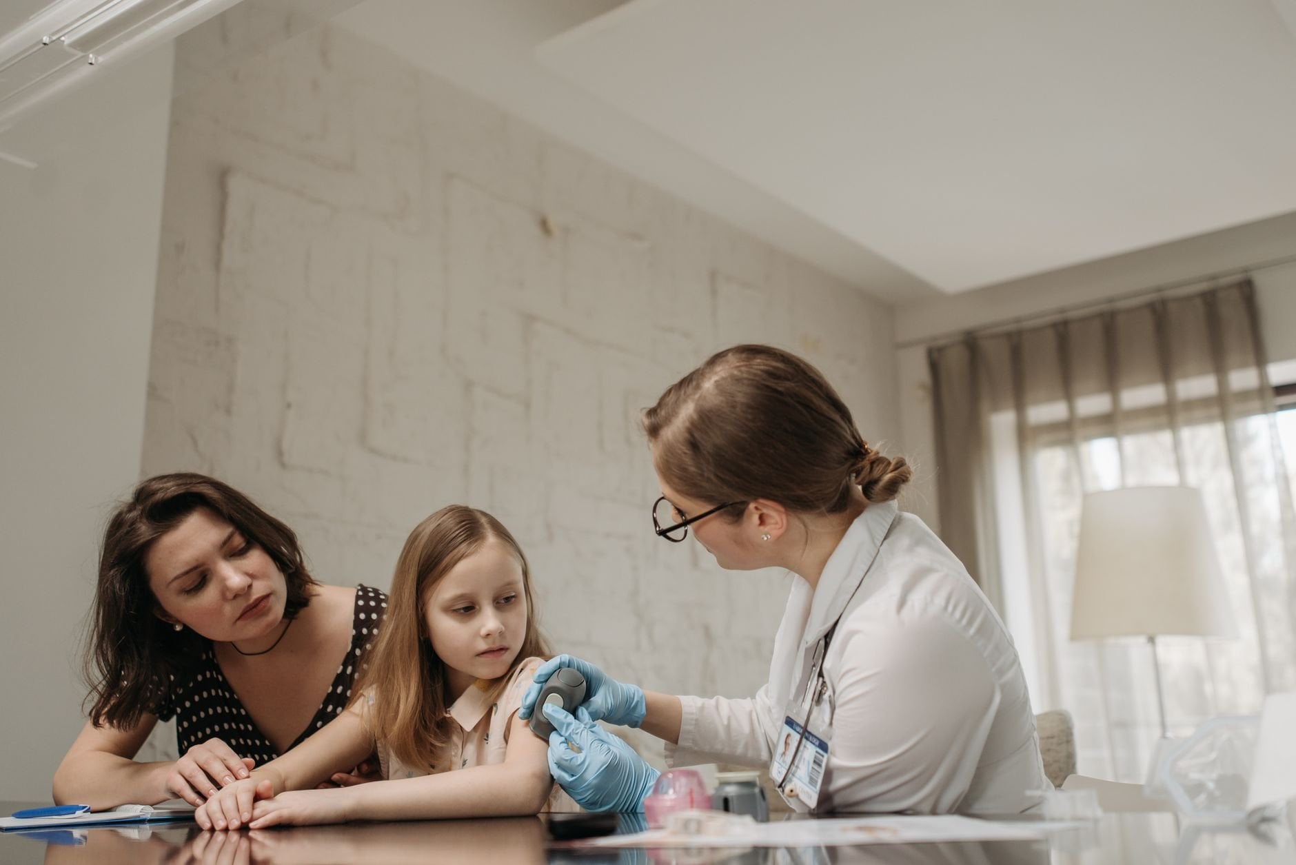 Mother and daughter consult with doctor about care in a medical office.